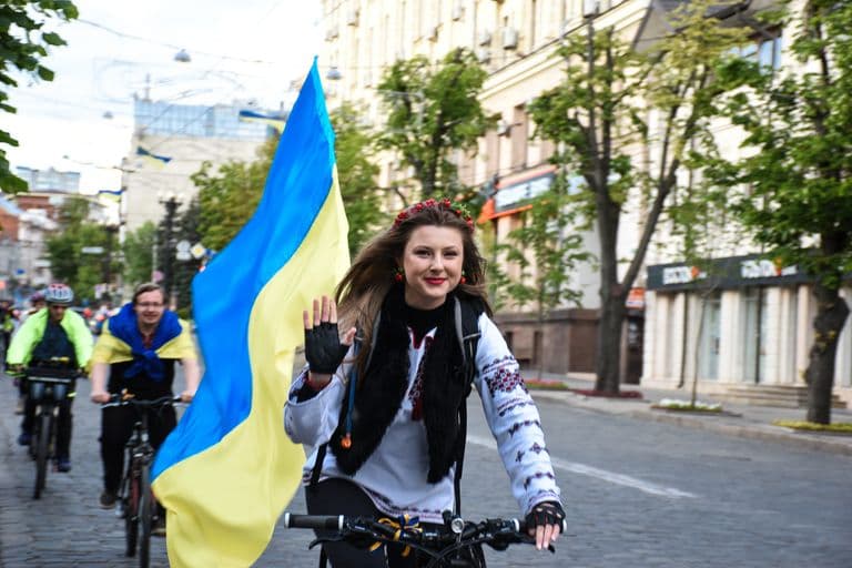 Woman in a vyshyvanka with the Ukrainian flag at a bike rally